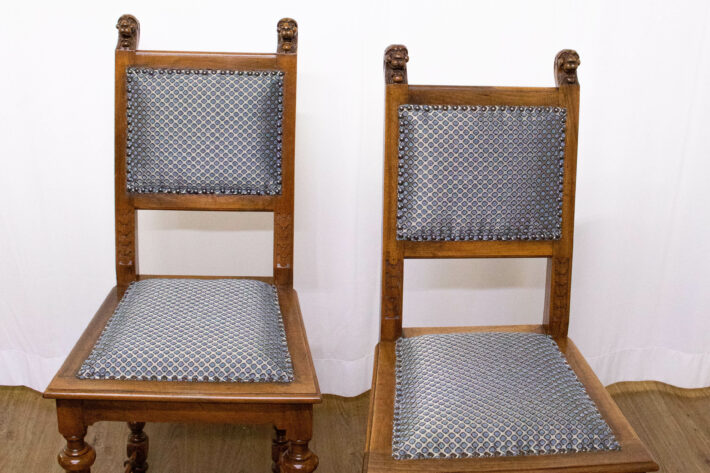 Beide neu bepolsterten geschnitzten Holzstühle in der Frontale. Die Polsterung ist weiß mit aquamarinblauen Punkten, die Stühle stehen vor einer weißen Wand.