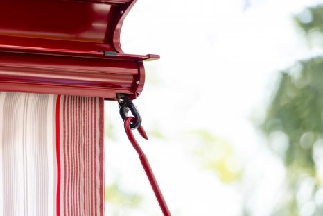 Nahansicht von hinten, ausgefahrene Kassettenmarkise mit Volant, Zoom auf Ausfahröse des Volant.