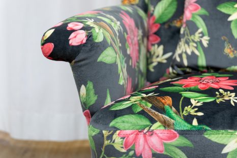 Frontalansicht schwarzer Samtpolstersessel von Haller, linke untere Ecke und Lehne. Stoff mit Rosa Lotusmuster, gepolstert von Haller Raumgestaltung in Sattelbach.