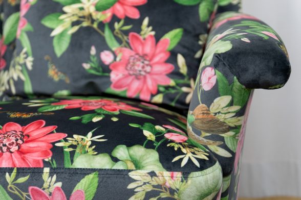Frontalansicht schwarzer Samtpolstersessel von Haller, rechte untere Ecke und Lehne. Stoff mit Rosa Lotusmuster, gepolstert von Haller Raumgestaltung in Sattelbach bei Horgenzell.