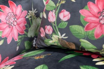 Nahansicht Sitzfläche von neu gepolstertem Sessel, schwarzer Samt mit Rosa-Lotusmotiv. Kissen mit gleichem Stoff, alles neu gepolstert von Haller Raumgestaltung in Sattelbach bei Horgenzell.